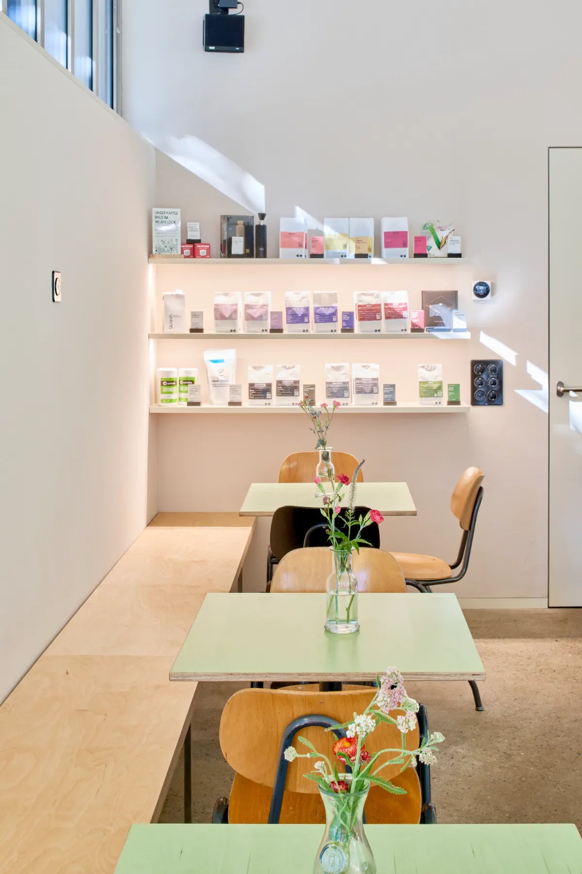 Café sommer Basel – Kaffee-Regal und Sitzplätze mit Blumen am Winkelriedplatz