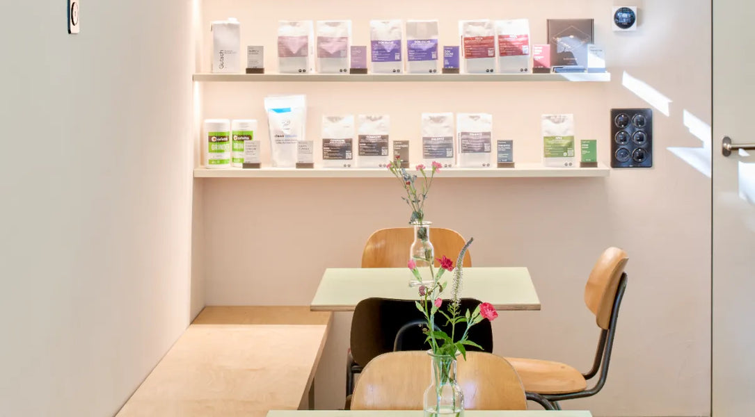 Café sommer Basel – Kaffee-Regal und Sitzplätze mit Blumen am Winkelriedplatz
