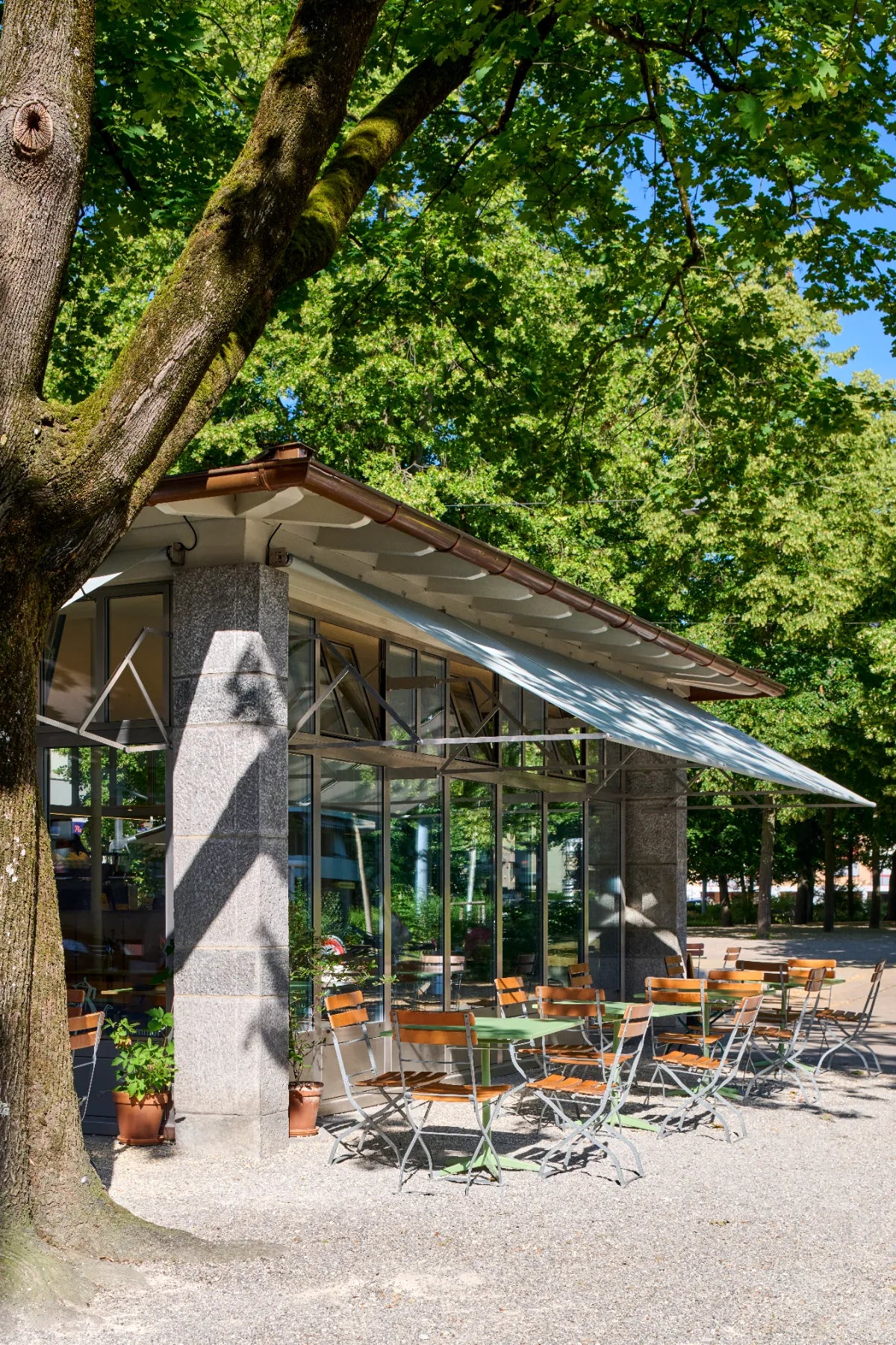 Café sommer Basel – Trafogebäude mit Aussenterrasse unter Bäumen am Winkelriedplatz
