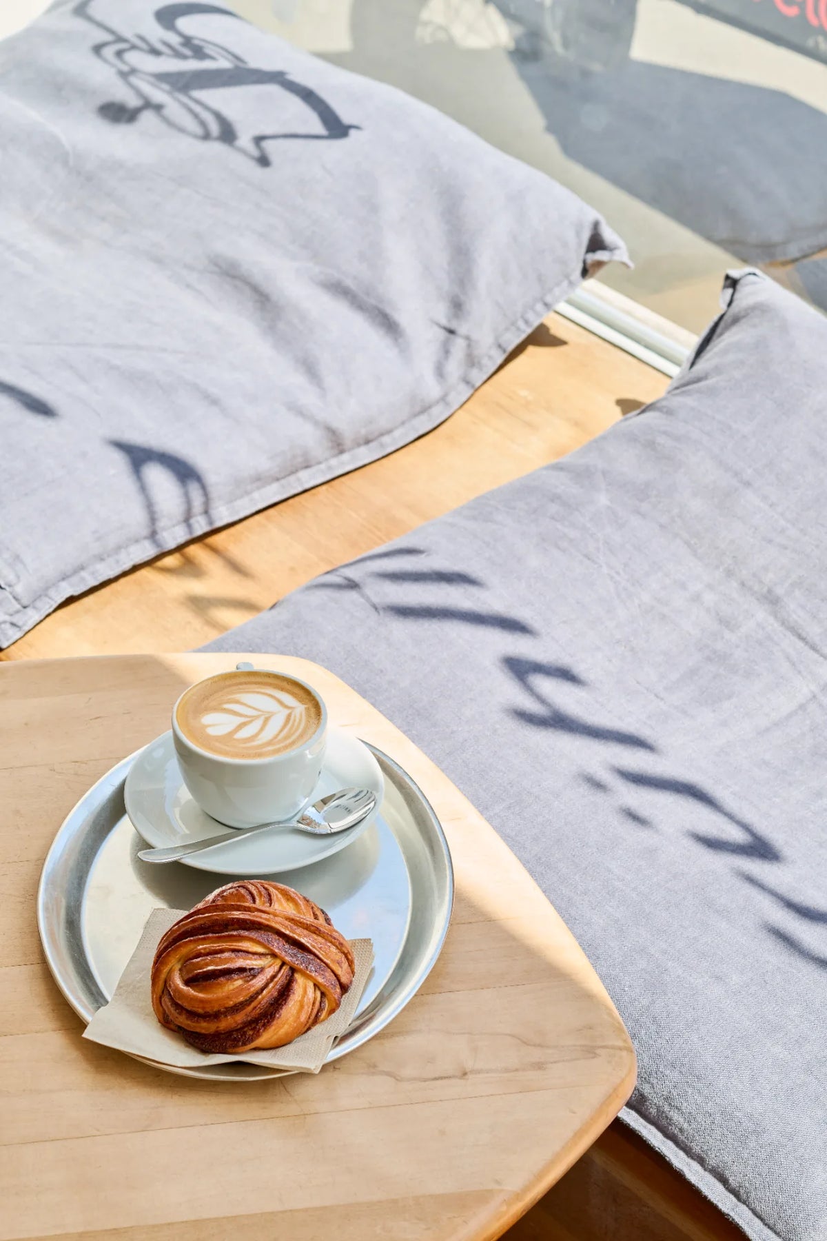 Tablett, Sitzkissen, Cappuccino und Zimtschnecke zum Frühstück im Café frühling Kleinbasel