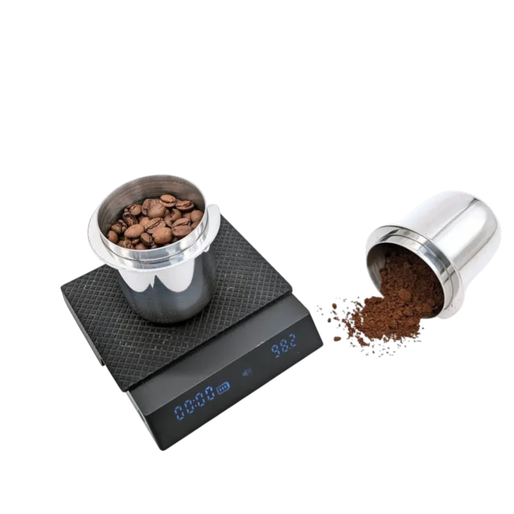 Zwei KM Messbecher 51mm, ein Messbecher ist auf einer Waage mit ganzen Kaffeebohnen, der andere liegt daneben mit bereits gemahlenem Kaffee